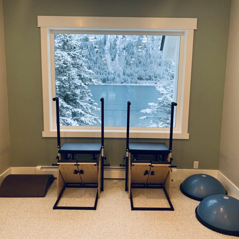 A room with two pilates chairs and a window, perfect for those seeking an invigorating workout.